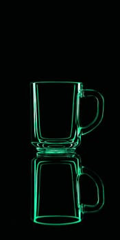 Just a glass on a black background with a reflection. Green colors. Isolated.