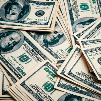Cash of hundred dollar bills, dollar background image. One hundred US banknotes are scattered over the background.