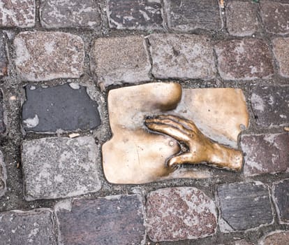 Amsterdam,Netherlands-December 30,2016:Between the stones of the Oudekerksplein, the square surrounding the Old Church in Amsterdam's Red Light District, one can spot this sculpture of a hand caressing a breast.The sculpture was set in 1993 by an anonymous artist.