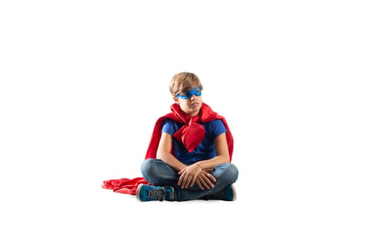 Superhero kid sitting on a wall that dreams something. Isolated on white background