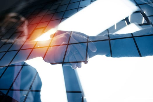 Handshaking business person in the office. concept of teamwork and business partnership. double exposure