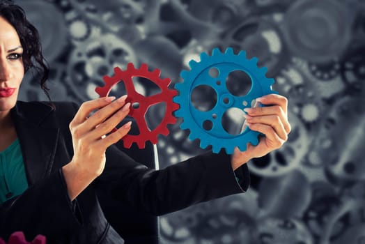 Businesswoman tries to connect gears pieces. Concept of Teamwork, partnership and business integration