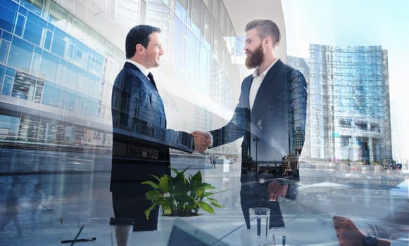 Handshaking business person in the office. concept of teamwork and business partnership. double exposure