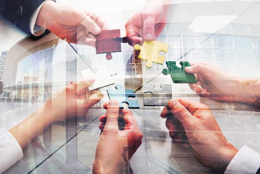Businessmen working together to build a colored puzzle. Concept of teamwork, partnership, integration and startup. double exposure