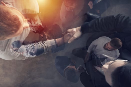Handshaking business person in the office. concept of teamwork and business partnership. double exposure