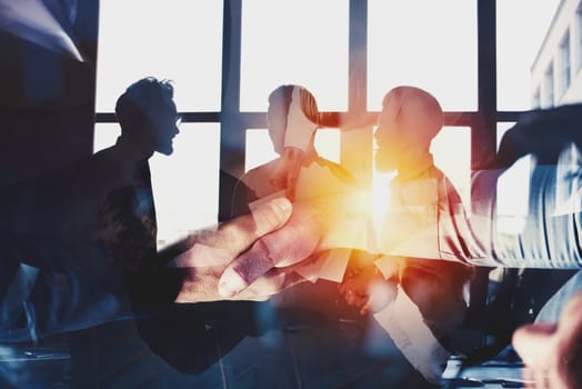 Handshaking business person in the office. concept of teamwork and business partnership. double exposure