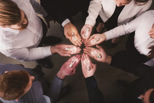 Teamwork and brainstorming concept with businessmen that share an idea with a lamp. Concept company startup