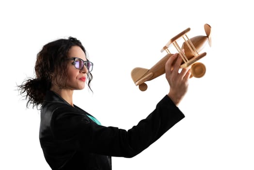 Businesswoman play with a wooden toy aircraft. Concept of company startup and business success. Isolated on white background