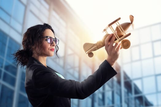 Businesswoman play with a wooden toy aircraft. Concept of company startup and business success