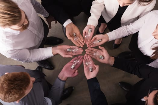 Teamwork and brainstorming concept with businessmen that share an idea with a lamp. Concept company startup
