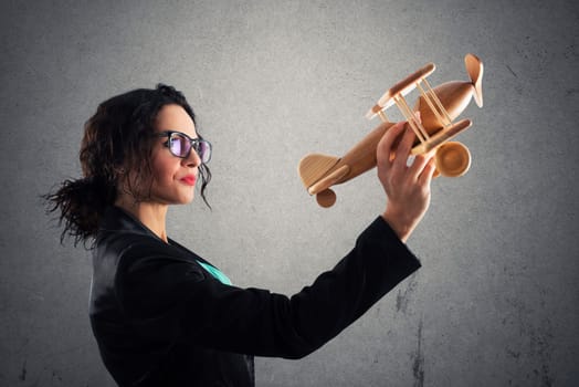 Businesswoman play with a wooden toy aircraft. Concept of company startup and business success