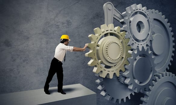 Businessman turning a gear business system