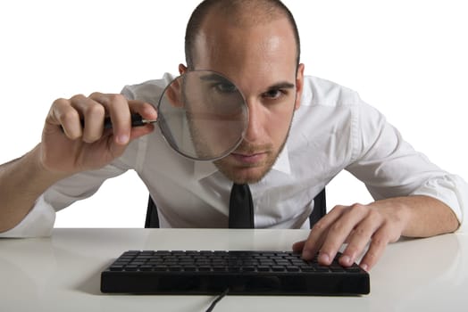 Businessman looks on the computer with a magnifying glass