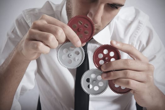Teamwork concept with businessman working with gear