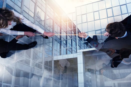 Rival business man and woman compete in office for the command by pulling the rope. double exposure