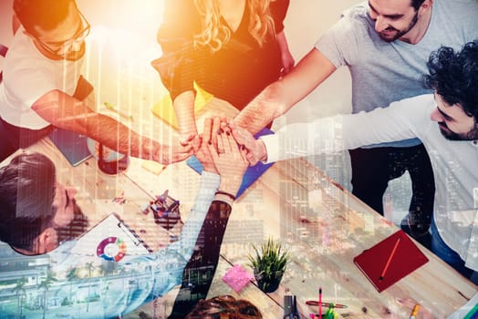Business people putting their hands together in office. Concept of integration, teamwork and partnership.double exposure