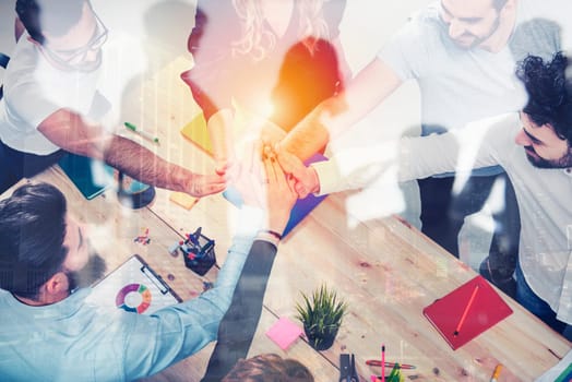 Business people putting their hands together in office. Concept of integration, teamwork and partnership.double exposure