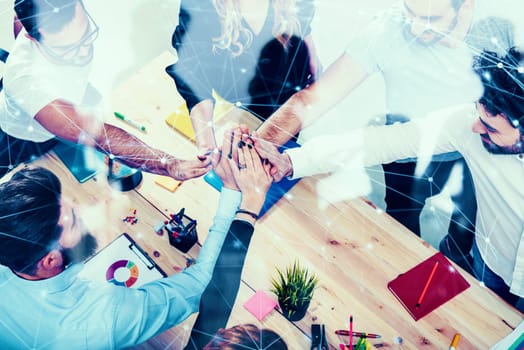 Business people putting their hands together in office. Concept of integration, teamwork and partnership.double exposure