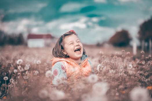 Sweet little girl having fun in spring dandelion field.