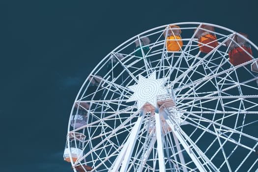 Colorful ferris wheel over blue sky - vintage color