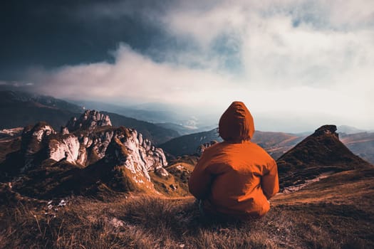 Woman sitting on cliff enjoying mountains landscape. Lifestyle concept. Traveling active adventure vacations.