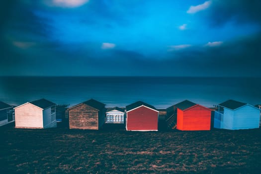 Colorful beach huts with stormy blue sky, beach of Tankerton near Whitstable in Kent, UK