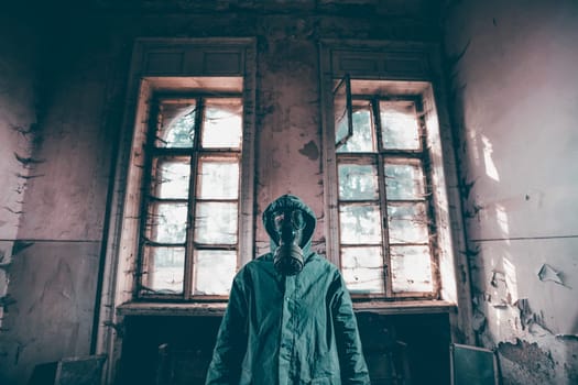 Post apocalyptic survivor in gas mask in a ruined building. Environmental disaster, armageddon concept.