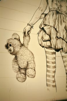 Teddy bear and girl on a facade