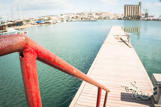 Red railing at the pier. Wide angle in a marina.