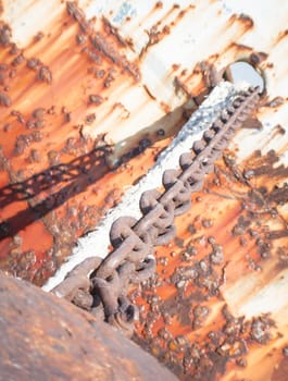 Rusty brown chain. Close up of a rust brown chain of a abandoned boat.