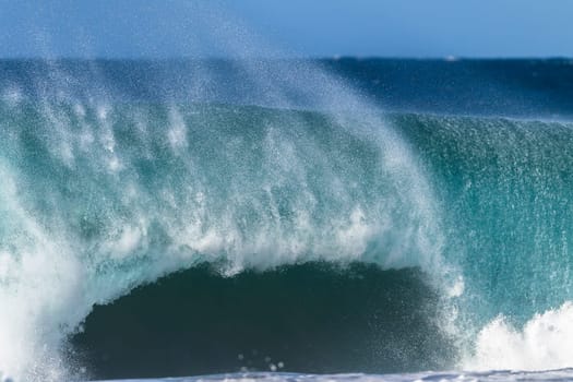 Ocean large wave swell crashing hollow water energy power of nature on coastline beach.