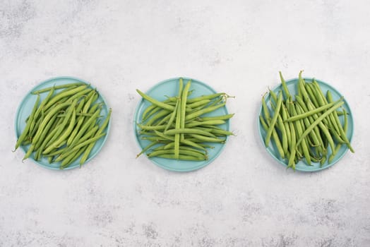 Green string beans on a textured background, empty space for text, fresh vegetables