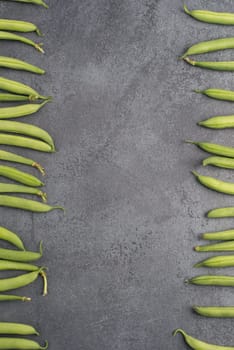 Green string beans on a textured background, empty space for text, fresh vegetables