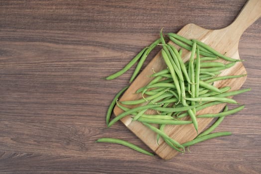 Green string beans on a textured background, empty space for text, fresh vegetables