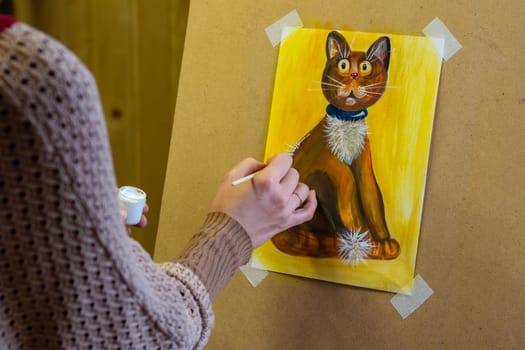 The artist draws a drawing on an easel, on the artist's hands and a drawing