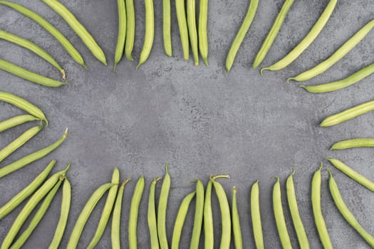 Green string beans on a textured background, empty space for text, fresh vegetables