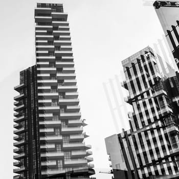 Abstract architectural background showing the Solaria Tower complex, Porta Nuova district in Milan, Italy. Geometric shapes and reflections glass windows overlap in a monochrome background.