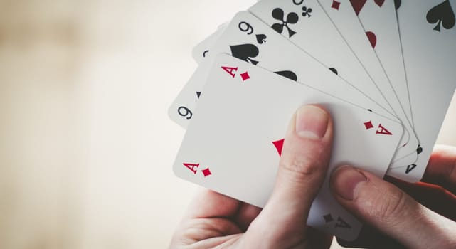 Young man is playing cards, cutout of his hands