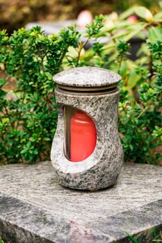 Old damaged grave lantern on a gravestone