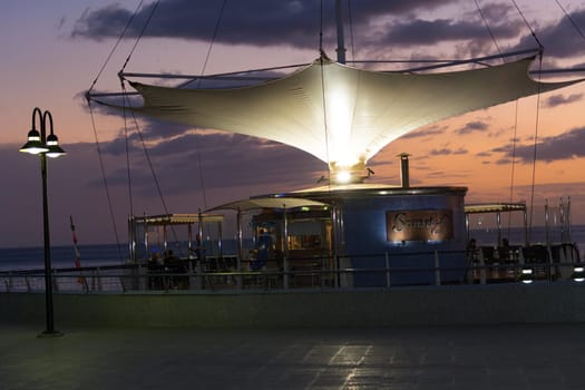 View of the sunset from the ship underway and in port. Colorful views of the water surface and sky with clouds.
