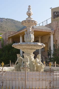 Antique fountain at garden. Blue water flowing from stone fountain. Design of antique fountain