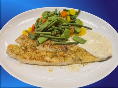Fried fish on green asparagus with salad