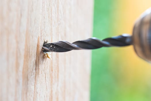 Do it yourself home handyman is using a drill for drilling wood