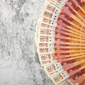 Russian money banknotes of five thousand rubles, background, banknotes are arranged in a fan on a gray background. Layout, mockup.