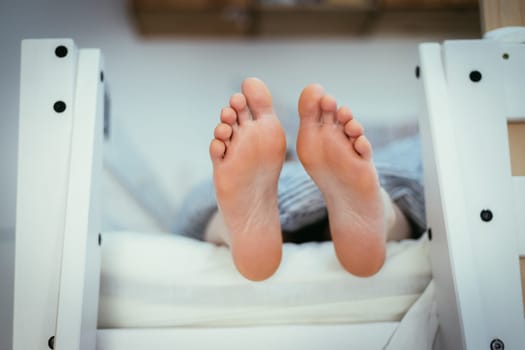 Girl with Barenaked feed is lying in her bunk bed, morning
