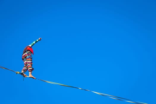 LANZO, ITALY - CIRCA OCTOBER 2020: Slackline athlete during his performance. Concentration, balance and adventure in this dynamic sport.