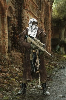 Nuclear post-apocalypse. Sole survivor in tatters and gas mask on the ruins of the destroyed city