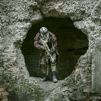 Nuclear post-apocalypse. Sole survivor in tatters and gas mask on the ruins of the destroyed city