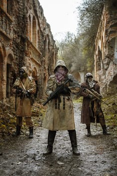 Nuclear post-apocalypse. Survivors in tatters and gas mask on the ruins of the destroyed city