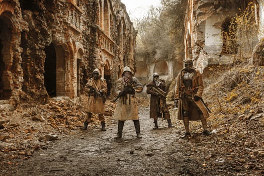 Nuclear post-apocalypse. Survivors in tatters and gas mask on the ruins of the destroyed city